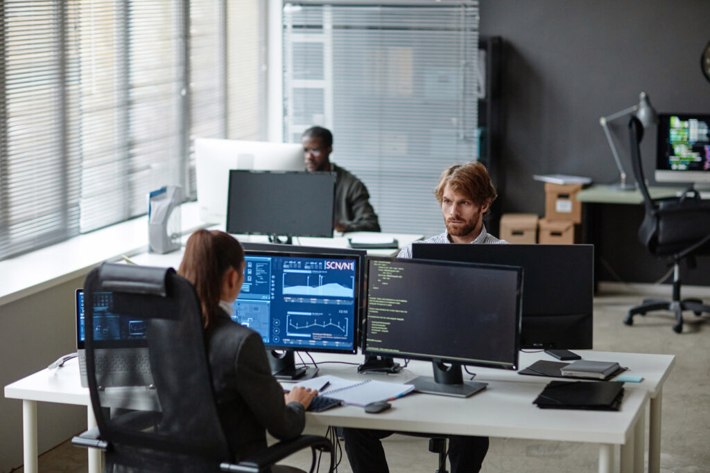 Three Cybersecurity Analysts work on their computers